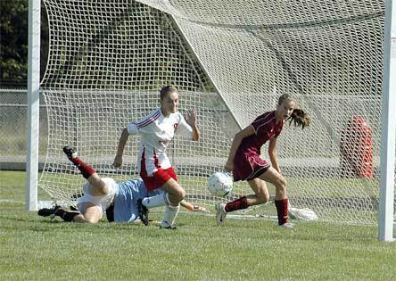 Sophomore midfielder Lauren Noltes tries to gain control of the ball while the Cascade goalkeeper is down