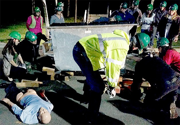 Members of the Marysville CERT class learn how to use leverage to lift a garbage bin to free a trapped dummy.