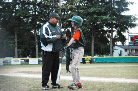 Ben Nygard chats with coach Carlos Gonzalez as he awaits his turn to bat in the fourth inning.