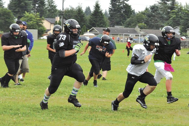 Members of the Marysville Youth Football Association’s Junior Black Chargers get warmed up during practice on Thursday