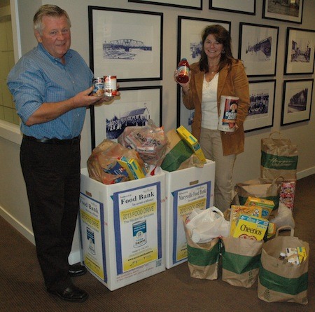 Marysville Windermere food drive coordinators Larry Peterson and Connie Redden show off some of their haul for the Marysville Community Food Bank in October.