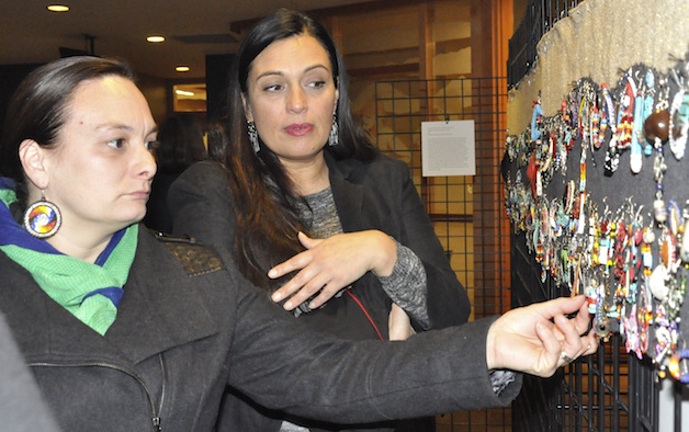 Theresa Sheldon and Deborah Parker examine the earrings that are on display at the Hibulb Cultural Center through the end of this month.