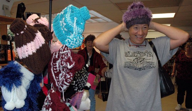 Eileen Hinkley tries on hats from Rene’s Celtic Faireisle Knits of Lake Stevens