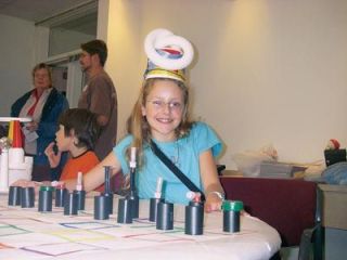Totem Middle School sixth-grader Elizabeth Holiway models the hat she created from recycled materials at the Sustainable Energy Fair in Everett Oct. 6. In front of her is a chess set made from milk bottle caps and used film containers. We wanted to use something out of the ordinary