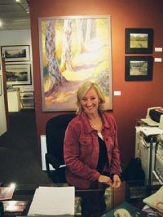 Karen Dales Birch Tree Trail hangs behind Gayle Picken in the new location of Gallery by the Bay in downtown Stanwood.