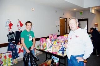Operation Marysville Community Christmas volunteers Austin Schulz and Bill Floyd help select gifts for the needy at the free toy store for Marysville Community Food Bank patrons. Shulz is one of many teens who pitched in this year.