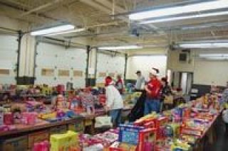 Volunteers from OMCC show visitors around the toy store last week as food bank clients selected gifts for their children. This was one of several rooms with toys and presents divided by age and interests for people to choose from.