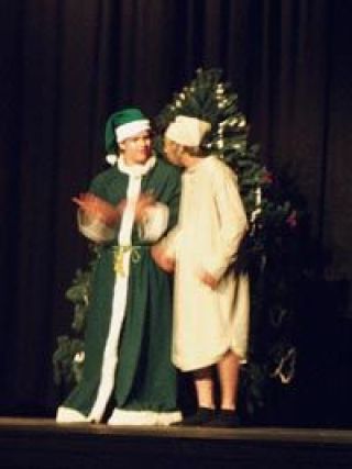 Robert Peiffle as the ghost of Christmas present and Kyle Williams as Ebenezer Scrooge in the Arlington High School production of A Christmas Carol on opening night in the old AHS auditorium.