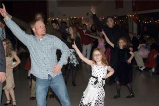 Fathers and daughters demonstrate a few of their best disco moves.