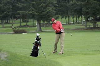 Junior Taylor Ashton chips the ball onto the putting green in a team exercise at Battle Creek Golf Course.