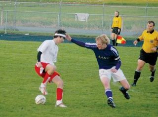 Senior defender Chad Deaver attempts to dribble the ball while keeping it away from the onrushing Lake Stevens offense.