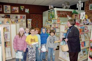 Quil Ceda Elementary School second-graders get a treat from BookWORKS owner Mary Burns during their annual scavenger hunt through Marysville on April 26. From left are Lauren Ghosn