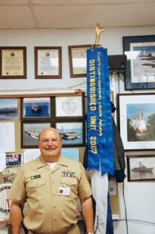 Marysville-Pilchuck High School Junior Reserve Officer Training Corps instructor Commander Randy Brasfield stands next to the Distinguished Unit Awards his classes have won for nine consecutive years.  He was selected a teacher of the year by the Challenger Center for Space Science Education.