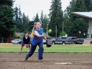 Welco pitcher Janet Hackney aims not just for the strike but to avoid a puddle near home plate while second baseman Mande Davis looks on.