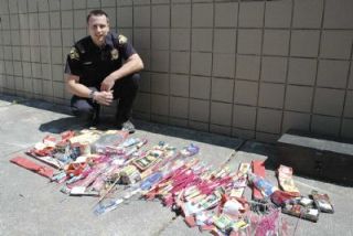 Marysville Police Officer Jake Robbins shows off some of the fireworks police confiscated in the days leading up to July 4. The items are mostly firecrackers and bottle rockets that are illegal to use in Marysville.