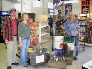 The owners of Hunters Corner gas station and store stand next to the still owned and operated by their grandfather Ira Pappy Hunter.  From left are Shannon and Melinda Ramey