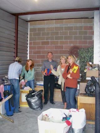 Members of the Marysville John L. Scott office peruse the offerings gathered so far for their Oct. 6 charity auction to benefit Snohomish County foster children.  The realtors are appealing to the community for quality donations of merchandise