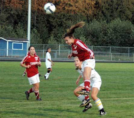 Junior midfielder Melissa Kirk jumps up to play an air ball intended for her Arlington mark. Kirk scored a goal for Marysville-Pilchuck in the fourth minute but was later sidelined by injury as she attempted her second.