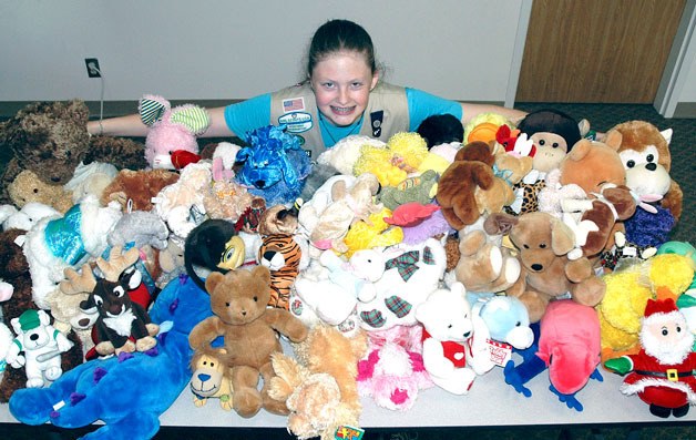 Arlington Girl Scout Kaitlyn Toomey shows off the more than 40 stuffed animals she collected for the Marysville Police Department.