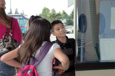 Nine-year-old Kevin Bautista scans the list of classes and teachers on the first day of school. His sister Helena
