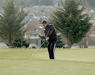 Grace Academy junior Ryan Bronder chips the ball onto the putting green as he and a few teammates play horse at Cedarcrest Golf Course.