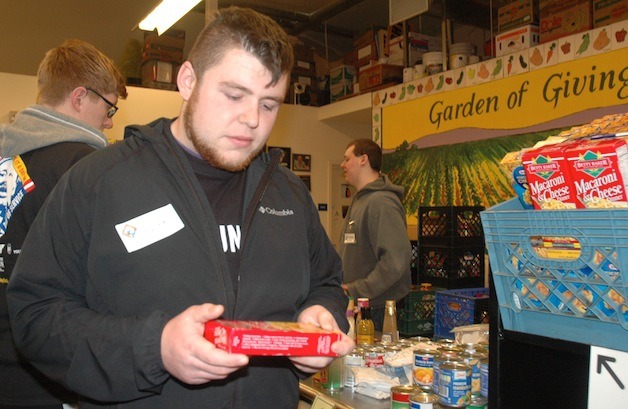 Lakewood High School senior Kalan Knott browses through the Marysville Community Food Bank's selection for its shoppers during the United Way of Snohomish County's Martin Luther King Jr. Day of Caring.