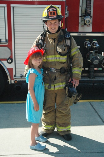 Quil Ceda Elementary student Courtney Taylor and Marysville firefighter Daniel Storer bond after their ride to school June 4.