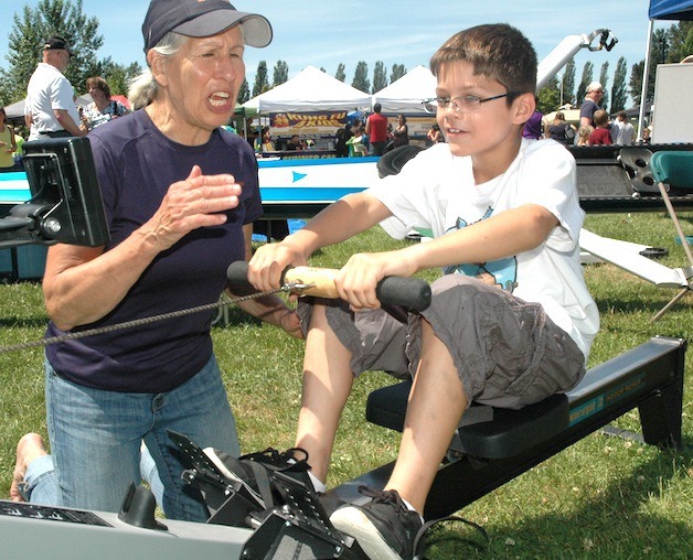 The North Cascades Crew's Pat Runyon puts 8-year-old Bennet Hamlin through his paces on the rowing machine at Healthy Communities Challenge Day June 6.