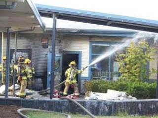 Local firefighters work to extinguish an exterior fire at Lakewood Elementary School.