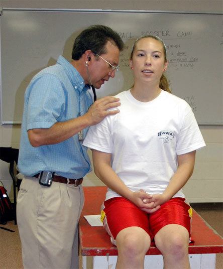 Dr. Hal Clark examines Marysville-Pilchuck junior Sacha Clow at a station testing athletes’ heart and lungs.