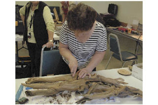 Teri Alverdes seeks to find the form within the castoff wood in Arline De Palma’s driftwood sculpture class at the Ken Baxter Senior Community Center Oct. 23.