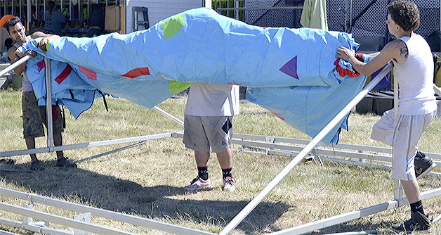 Workers put together a booth that will be part of the Marysville Strawberry Festival carnival when it opens at Marysville Middle School June 18.