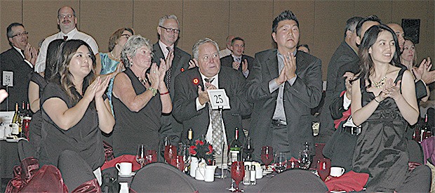 Those attending the gala at the Tulalip Resort Casino stand and applaud a speaker.