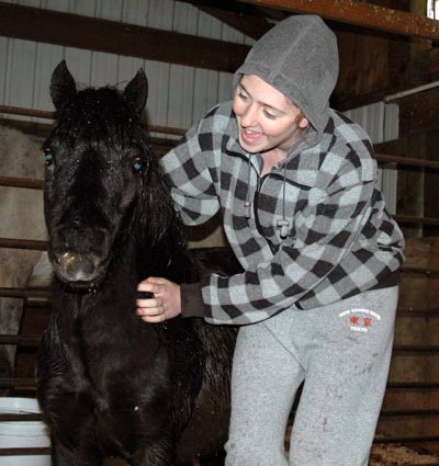 Cascade High School student Meleah Zuvela scratches a horse at the Equine Rescue Alliance May 29.