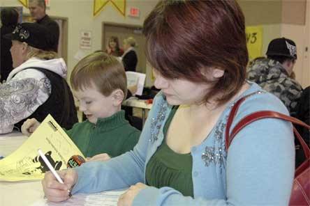 Four-year-old Alister Teske colors while his mom