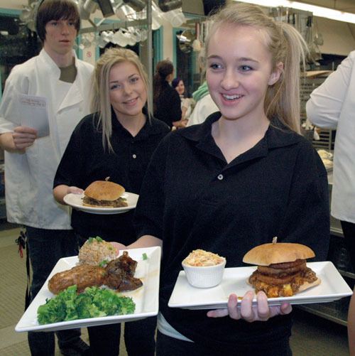 Marysville Getchell School for the Entrepreneur freshmen Emma Artz and Amy Harwood bring customers’ lunch orders out to the dining area of the School House Cafe.