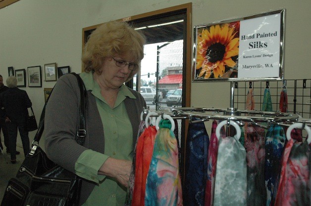 Snohomish's Penny Goodwin checked out the hand-painted silk scarves of Marysville's Karen Lyons at the second annual 'It's Raining Art' show and sale on April 27