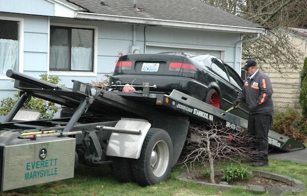 A stolen vehicle is towed out of the front yard of a house at 47th Avenue and 75th Street March 4.