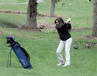Arlington golfer Aarika Montanez chips the ball on the front nine at Cedarcrest Golf Course as a pair of ducks go about their business near the water trap just behind her.