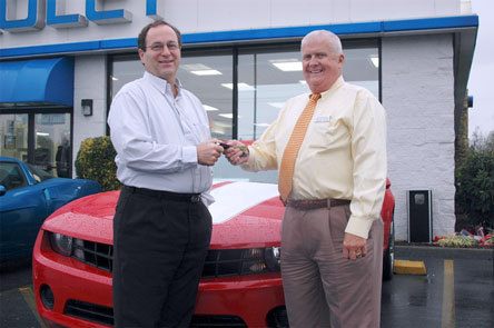 Roy Robinson Chevrolet President Gordon Bjorg hands Dave Edmonds the keys to a 2010 Chevrolet Camaro Edmonds won during the annual Rotary Club of Marysville auction.