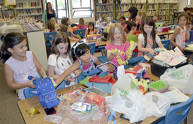 Girl Scouts pick out items to put in their Joy Boxes.
