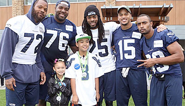 Jay and his sister meet with Seahawk players at practice Friday in Renton.