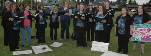 Members of the Northern Sound Choirs sing in protest outside the Marysville School District Service Center on May 7.
