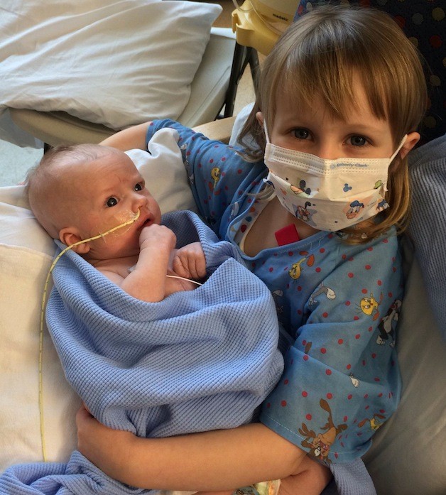 Spencer Norton is held by his sister Olivia for the first time at Seattle Children’s Hospital.