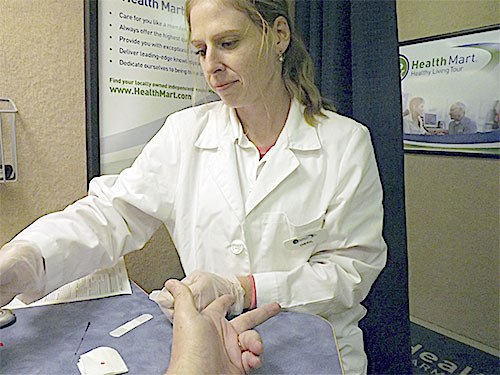 Cheryl Graham works on a patient getting a free screening at Hilton Pharmacy in Marysville Nov. 12.