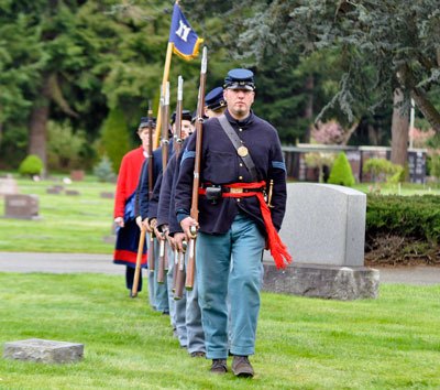 Local re-enactors of Civil War unit the 11th Pa. Infantry Co. 1 march behind Adam Carter toward the grave of Cyrus Marcus Armbrust