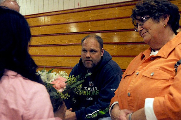Mike Spitzer being presented with flowers from the Marysville booster club in condolences to his wife Kerrie Spitzer who passed away from breast cancer Oct. 23 at Marysville-Pilchuck High School.