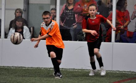 Nathan Morford of U-10 Dynamite clears the ball with Leah Taylor of U-10 Wildcats in hot pursuit.