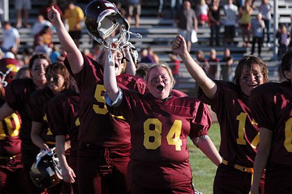 Lakewood youth football association mom Jamie Miller celebrates with her team after defeating the Arlington moms 16-0 at Haller Middle School.