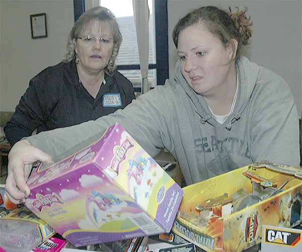 Mary Lea Hebert helps Sara McCarter pick out toys at Arlington event.